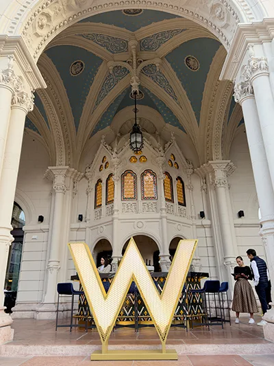 The arcaded terrace of the W luxury hotel with its big logo, on Andrássy Avenue