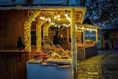 wooden booths illuminated for the night selling handcrafted gifts and food at Vajdahunyad Castle