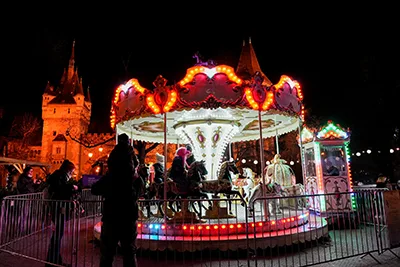 carousel lit up at night in front of Vajdahunyad Castle