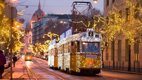 Tram 2 decorated with LED string lighting in the Christmas season, the dome of the Parliament in the baclground at dusk