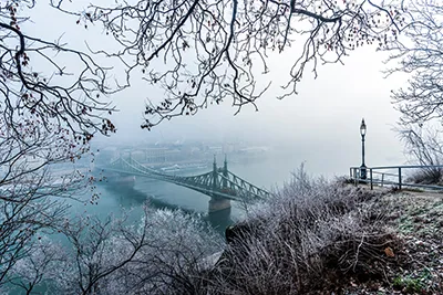 view of the Liberty Bridge form gellert Hill on a foggy winter morning
