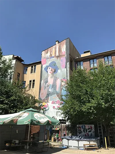firewall art in Budapest: depicts a young woman wearing a blue hat