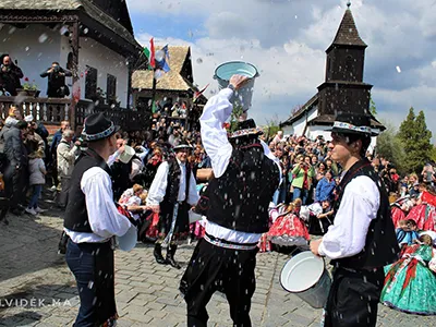 men and women dressed in folk costume at the Easter Festival in Hollókő village, men pouring water from buckets on the women as tradition