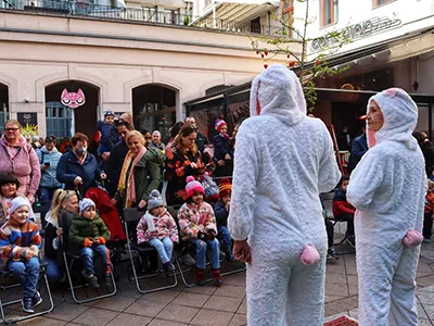 Two adults dressed in white bunny costume entertaining chiildren in Gozsdu Court