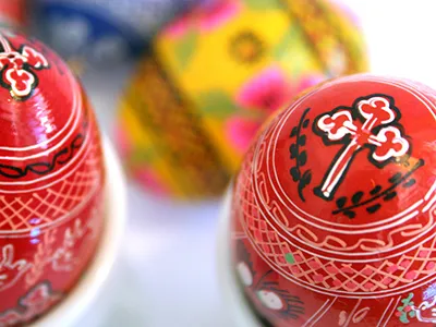 2 red and a yellow Easter egg with folk motifs painted on them