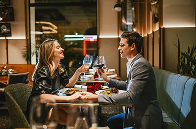 A young couple toasting with glassof wine and having romantic dinner in Sessions at Hard Rock Hotel Budapest
