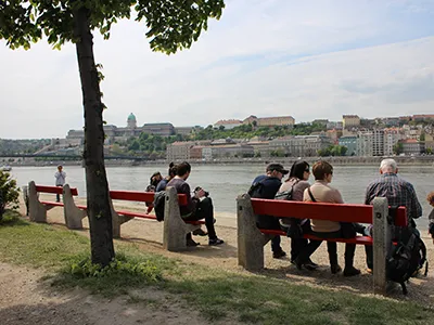 People sitting on benches on the Danube promenade in early spring