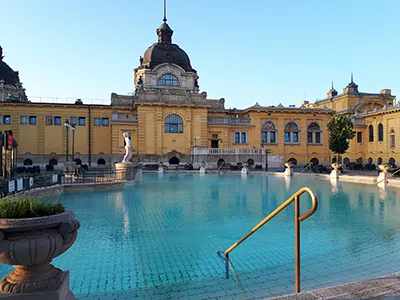 photo showing the large outdoor pool and the yellow facade of the Széchenyi bath