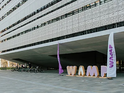 the"WAMP" logo from large purple mock up letters in front of the Ethnography Museum