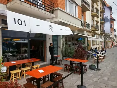 The terrace of 101 Bistro on Széll Kálmán Square with red tables