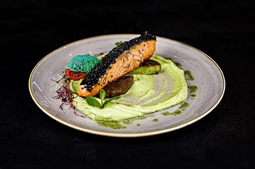 salmon steak served with pea puree and pea fritters
