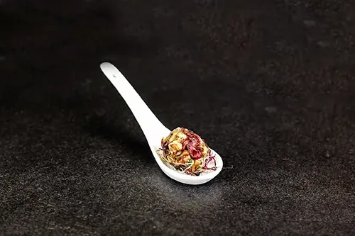 cheese ball with dried cranberry and pecun nuts served in a small white spoon